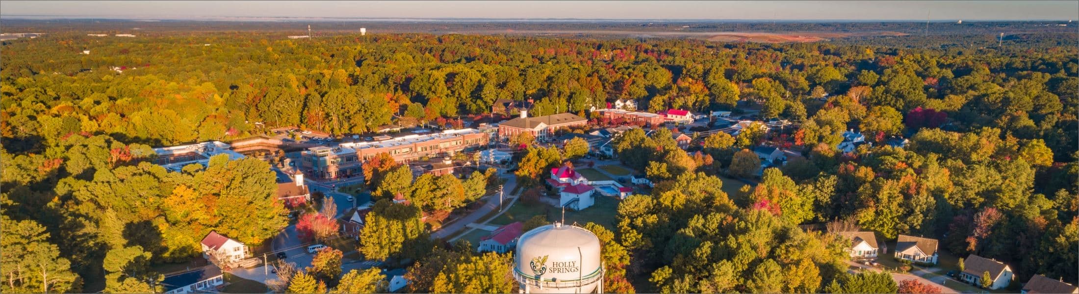 An actual autumn aerial of downtown Holly Springs, North Carolina, with its water tower and wooded horizon.